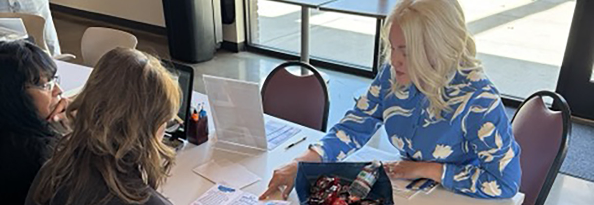 A group of women sitting at a table looking at papers.