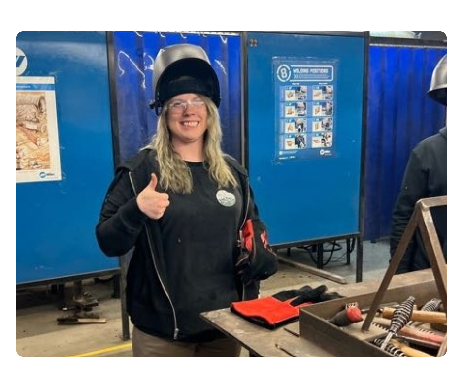 A person wearing a hat and standing next to a machine.