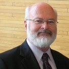A man with a white beard and glasses.