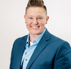 A man in a suit smiling.