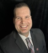 A man in a suit smiling.