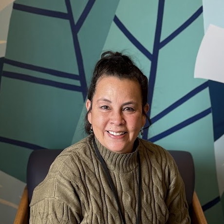 A man smiling in a chair.