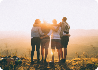 A group of people standing in a field with the sun behind them.