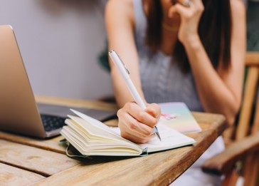 A woman writing on a piece of paper.