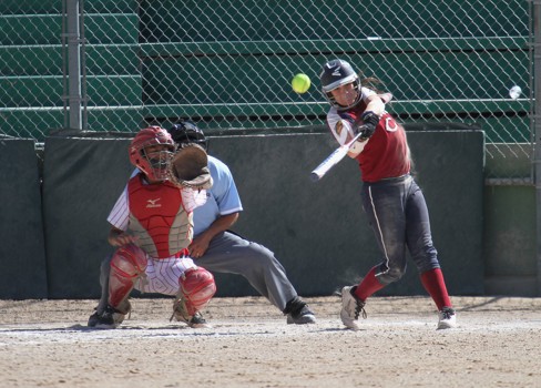 A baseball player hitting a ball with a bat.
