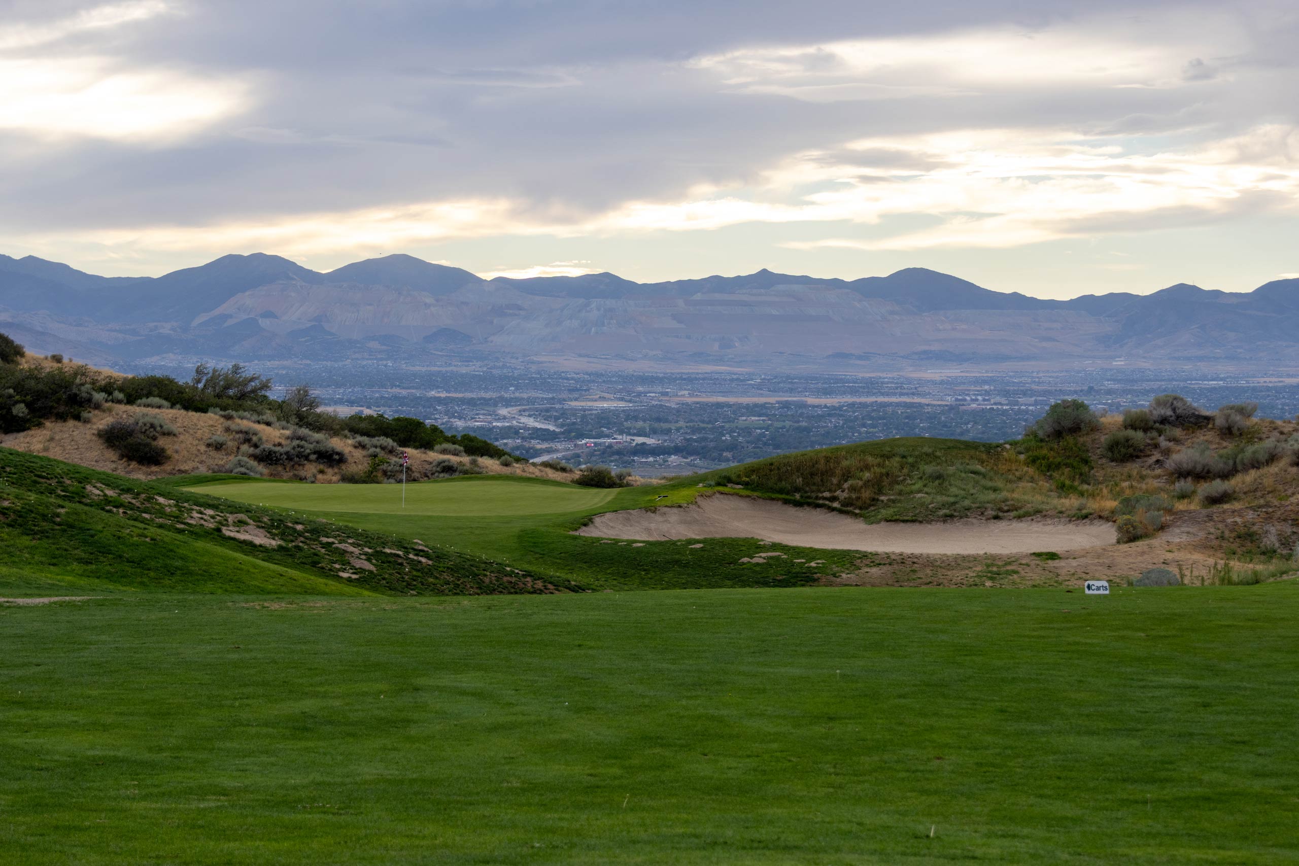 A golf course with a body of water in the background.