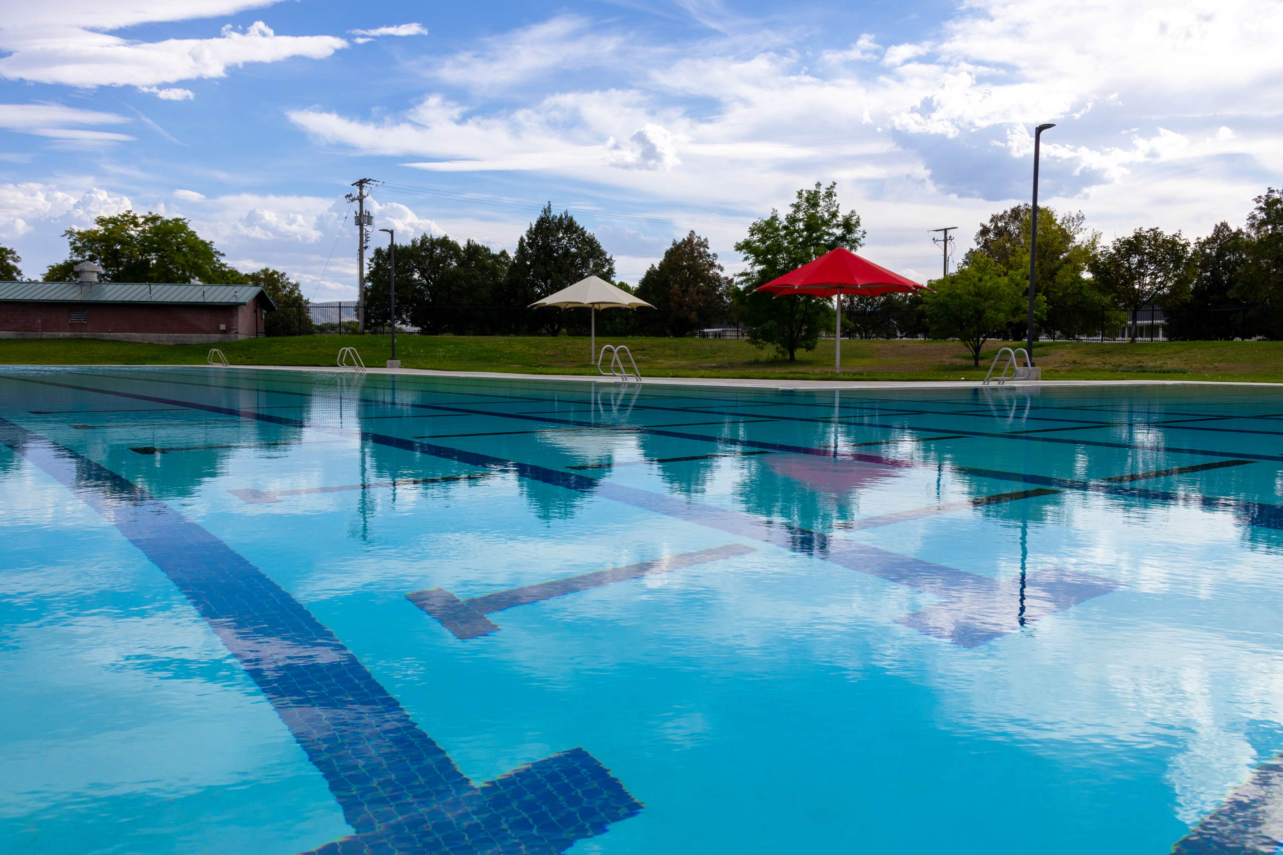 Swimming lanes and umbrellas at South County Outdoor Pool in Riverton, Utah