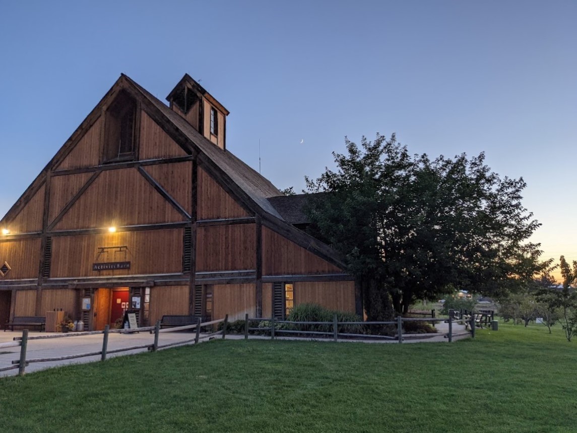 A brown barn with green grass.